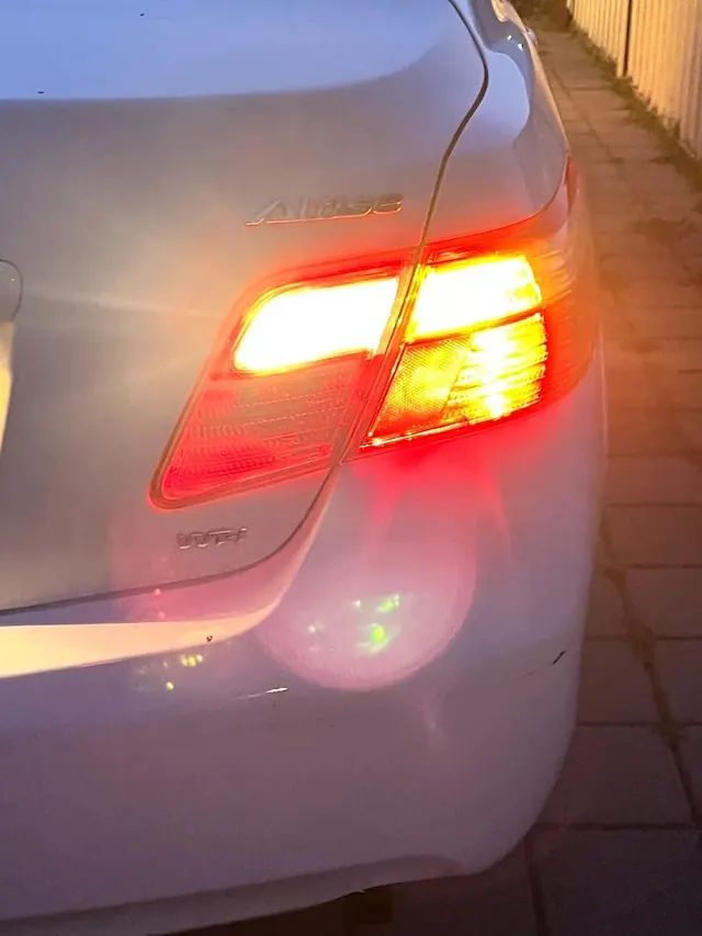 Toyota Corolla with its repaired rear tail light lit up after dark